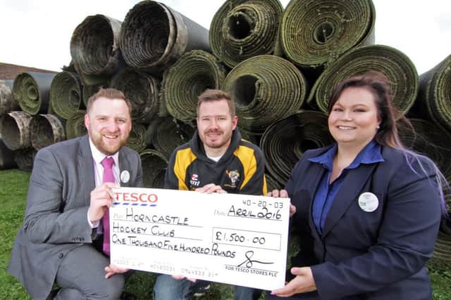 Tesco store manager Ben Manual with Jen Reynolds presents the cheque to Horncastle Hockey Club vice-chairman David Seymour. Photo: Brian Pickering