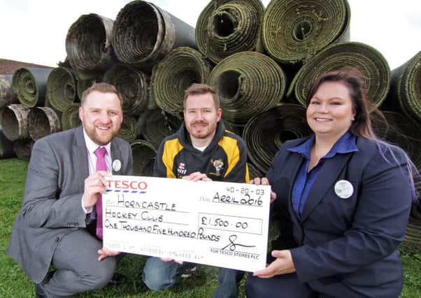 Tesco store manager Ben Manual with Jen Reynolds presents the cheque to Horncastle Hockey Club vice-chairman David Seymour. Photo: Brian Pickering