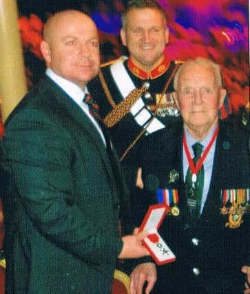 Pat Hagan (right) receives the medal from Royal Marines Corps Regimental Sergeant Major, the Senior RSM, WO1 (RSM) PS Gilbey RM. In the background is Royal Marine Bugler Dave Nevatte.