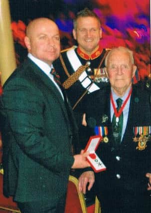 Pat Hagan (right) receives the medal from Royal Marines Corps Regimental Sergeant Major, the Senior RSM, WO1 (RSM) PS Gilbey RM. In the background is Royal Marine Bugler Dave Nevatte.