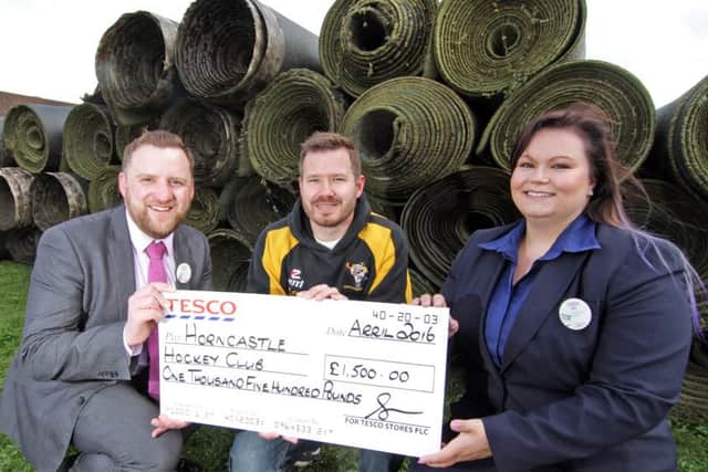 Store Manager, Ben Manual with Jen Reynolds, Community Champion, presenting £1,500 to David Seymour, Vice-Chairman of Horncastle Hockey Club in front of all the old pitch surface. EMN-160427-092043001