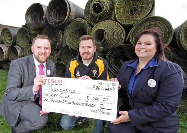 Store Manager, Ben Manual with Jen Reynolds, Community Champion, presenting Â£1,500 to David Seymour, Vice-Chairman of Horncastle Hockey Club in front of all the old pitch surface. EMN-160427-092043001