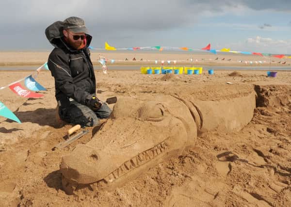 Sand sculptor Jamie Wardley.creating an alligator at th sand sculpting workshops held on Central Beach in Skegness. ANL-160205-104748001