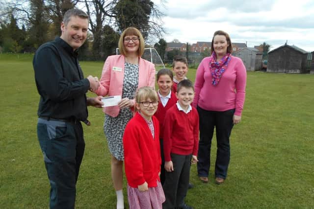 Pictured are Chris Baxter, Director (left) and Christie Baxter (right) from D C Baxter (Motors), presenting a cheque in conjunction with Blakemore Foundation (SPAR) to headteacher Laura Suffield and some of the pupils from the School Council. EMN-160429-145244001