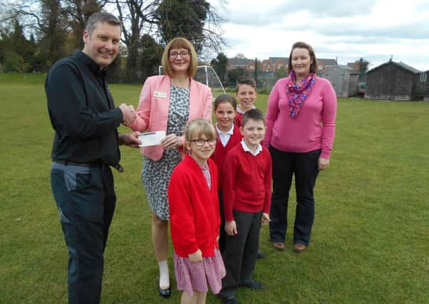 Pictured are Chris Baxter, Director (left) and Christie Baxter (right) from D C Baxter (Motors), presenting a cheque in conjunction with Blakemore Foundation (SPAR) to headteacher Laura Suffield and some of the pupils from the School Council. EMN-160429-145244001