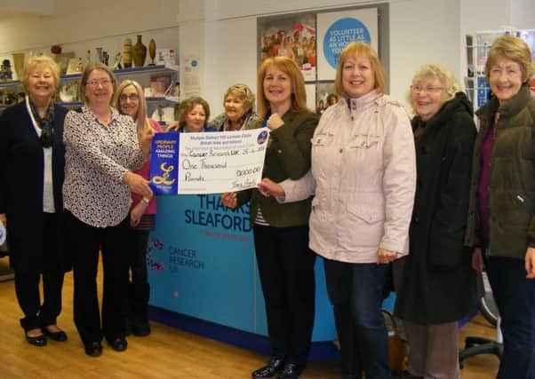 Sleaford Lionesses present ?1,000 to the Cancer Research UK shop in town. Anne Brown, the new shop manager is pictured with Tracy Arnold, Lionesses president, watched by previous shop manager Marjorie Johnson and other volunteers and Lionesses. EMN-160505-112217001