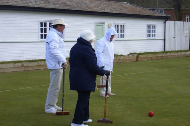 Barrie Darling and Anne Potter from Woodhall Spa Croquet Club watch a Norwich player decide where to hit the red ball.