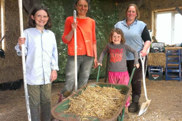 Permaculture teacher Hannah Thorogood and a family that comes to help out on the project. EMN-160516-095149001