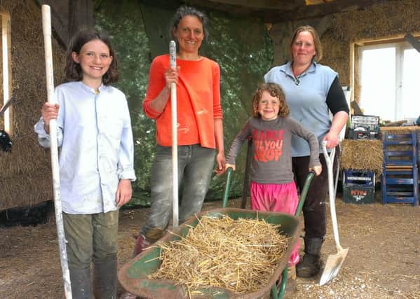 Permaculture teacher Hannah Thorogood and a family that comes to help out on the project. EMN-160516-095149001
