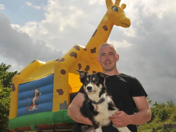 James Dooley and Rambo in front of their bouncy castle. Photo: TONY JONES ANL-160530-103702001