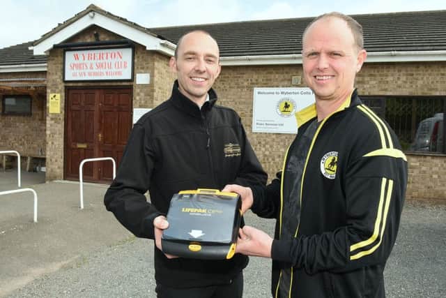 Defibrillator at Wyberton Sports Club bought with money raised by Boston Sausage. L-R Scott Palmer - director of Boston Sausage, Lathon Millar - vice chairman of Wyberton Football Club