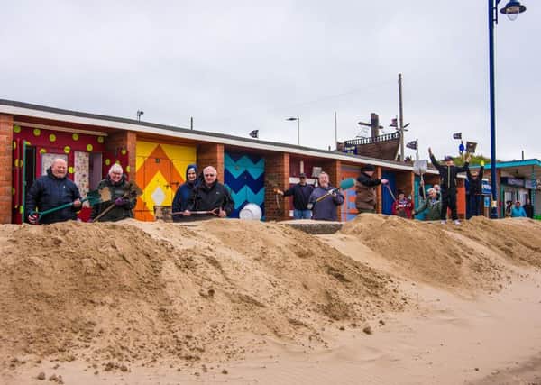 Community helpers pitched in to clear the sand.