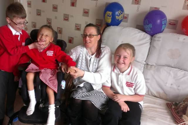 Claire Little with her disabled daughter Hope, 5, in the chair she would like replaced with the same model, and son Kai, 8, and Rose, 10. ANL-160507-065501001