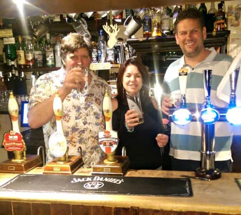 Cheers: Richard Stockdale (left) with Shirley Hargraves and  Stuart Kilby behind the bar at the White Hart Inn