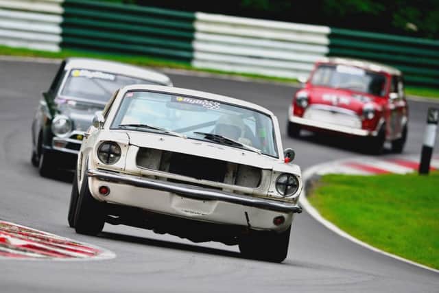 Ford Mustang, Lotus Cortina and Mini Cooper in a typical scrap at the front of an Historic Touring Car race.
