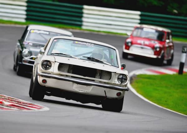 Ford Mustang, Lotus Cortina and Mini Cooper in a typical scrap at the front of an Historic Touring Car race.