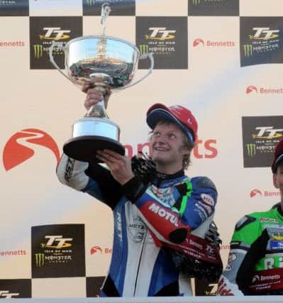 Ivan Lintin raises his trophy on the Isle of Man TT podium. Photo: www.iomtt.com