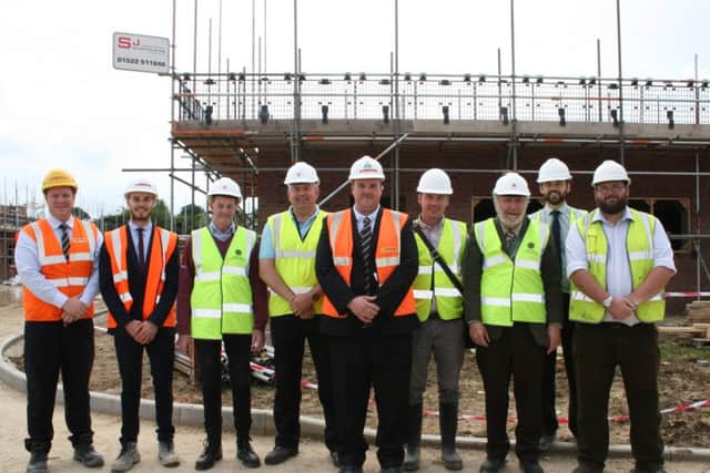 NKDC members and officers with representatives from Lindum Construction outside the Passivhauses being built at Kyme Road, Heckington. EMN-160623-155653001