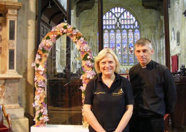 Interflora floristry display team member Janet Boast from Nelson in Lancashire and Rev Phillip Johnson with the floral arch on display. EMN-160624-170127001