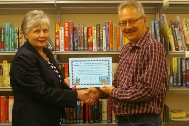 Heckington Parish Council chairman Jan Palmer receiving the Heckington Village Trust Award from HVT its chairman Andy Garlick in the community library at the council building in St Andrew's Street, Heckington. EMN-160629-110115001