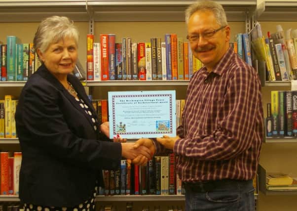 Heckington Parish Council chairman Jan Palmer receiving the Heckington Village Trust Award from HVT its chairman Andy Garlick in the community library at the council building in St Andrew's Street, Heckington. EMN-160629-110115001