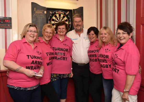 The Turnor Arms ladies' darts team pictured with Wolfie Adams. Photo: John Edwards