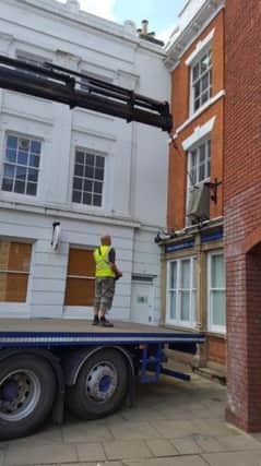The safe prepares to take flight from the first storey window at Wilkin Chapman LLP Solicitors in Louth's Cornmarket.