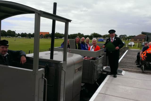 Volunteer Chris Bates waves the flag to allow the first passengers to experience a ride on a renovated WW1 wagon at the Lincolnshire Coast Light Railway. ANL-160713-172144001