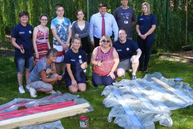 Tesco staff busy brightening up the outdoor area for patients and staff at the Pilgrim School in Sleaford. EMN-160726-002413001