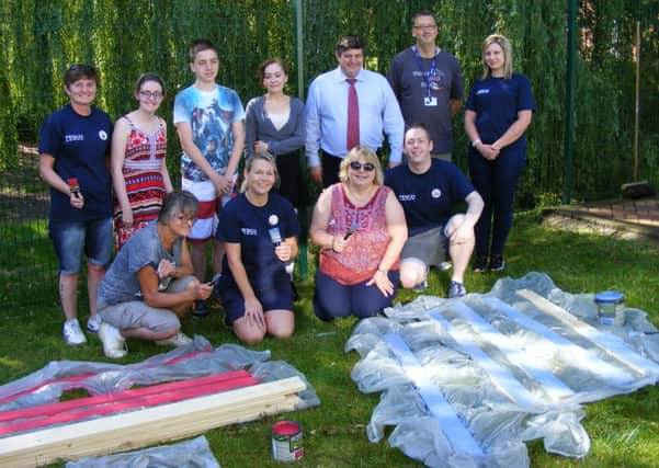 Tesco staff busy brightening up the outdoor area for patients and staff at the Pilgrim School in Sleaford. EMN-160726-002413001