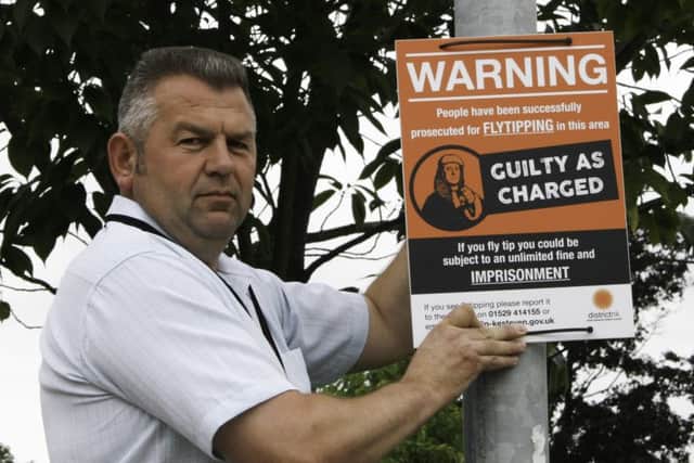 Coun Richard Wright pictured with a fly tipping sign. EMN-160725-183543001