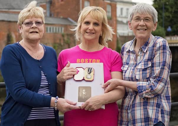Families reunited. Anne Halliday (right) with sister Joan Howard (left) and Sue Robinson holding her scrapbook and the medal awarded to Samuel Pope. The steps on the opposite side of the river, to the left of my Joans shoulder, is the point at which Samuel entered the water.