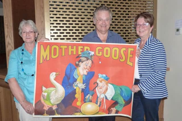 Pam Cluff (Left) and Mike Cluff holding one of the posters advertising a production of Mother Goose with Caistor WI President Rachel Grainger. (Lin) EMN-160908-164242001