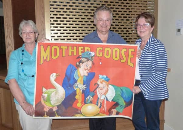Pam Cluff (Left) and Mike Cluff holding one of the posters advertising a production of Mother Goose with Caistor WI President Rachel Grainger.  (Lin) EMN-160908-164242001