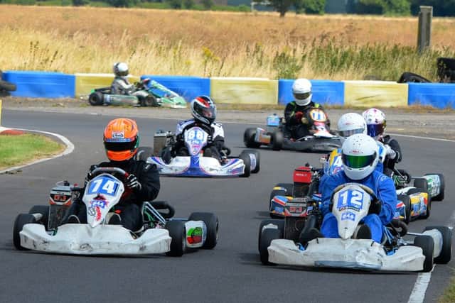 Jack Jones 74 and Kurt Davies 12, side by side out of the first corner as Samantha Neve 8 (Peterborough) runs wide in the background. EMN-161208-114818002