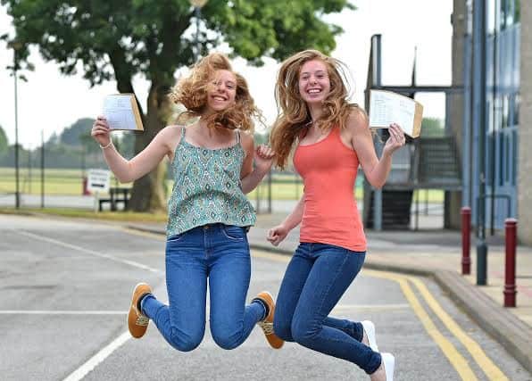 Twins Amy (left) and  Emma Davies jump for joy after getting their results EMN-160818-082333001