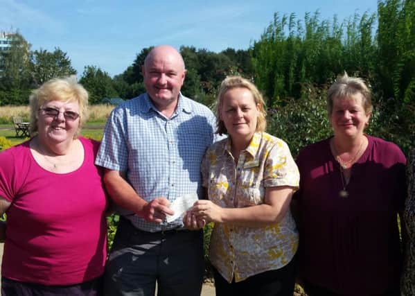 Linda Sanderson, Butterfly Hospice Trust Manager receives a cheque for Â£325 from Keith Lamming and his family.