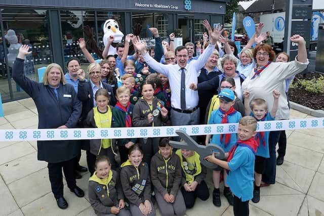 Callum Beeching (6) cuts the ribbon to open the store watched by store staff and Beavers, Brownies, Cubs, Scouts and Leaders from the 1st Hibaldstow and Scawby group.
? Tim George/ UNP 0845 600 7737
Co Op 35341 Hibaldstow EMN-160826-083211001