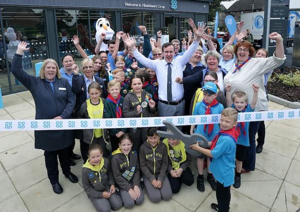 Callum Beeching (6) cuts the ribbon to open the store watched by store staff and Beavers, Brownies, Cubs, Scouts and Leaders from the 1st Hibaldstow and Scawby group.
? Tim George/ UNP 0845 600 7737
Co Op 35341 Hibaldstow EMN-160826-083211001
