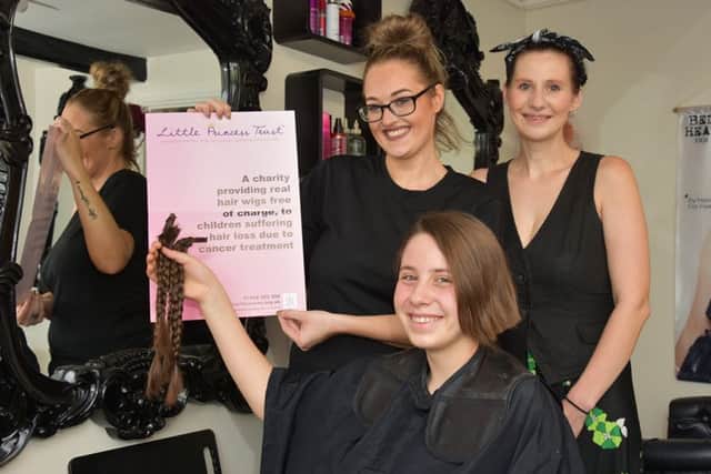 Ellie Rose Nash holds her platts which hair stylist Megan Flanagan cut off for charirty. Also pictured is Ellie-Rose's mum Nicky.
Photo John Edwards. EMN-160828-133041001