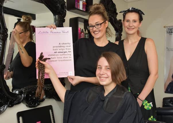 Ellie Rose Nash holds her platts which hair stylist Megan Flanagan cut off for charirty. Also pictured is Ellie-Rose's mum Nicky.
Photo John Edwards. EMN-160828-133041001