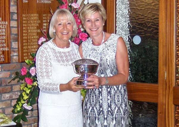 Anne Wallhead is seen presenting the Lady Captain's Rose Bowl to Judith Flevill (right).