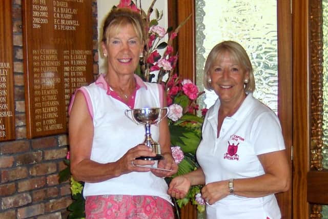 Jacqui Short is seen receiving the Nora Royle Trophy from Lady Captain Anne Wallhead.