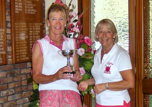 Jacqui Short is seen receiving the Nora Royle Trophy from Lady Captain Anne Wallhead.