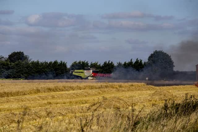 The combine harvester in the field as flames take hold of the cut straw. Photo: Colin Brittain. EMN-160831-134224001