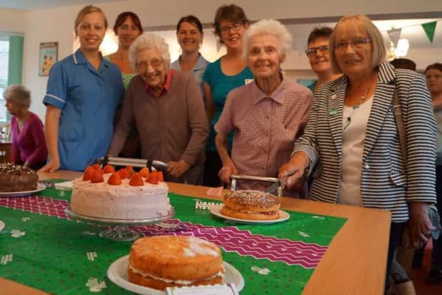 Staff and residents with the Bake off entries EMN-160709-084610001