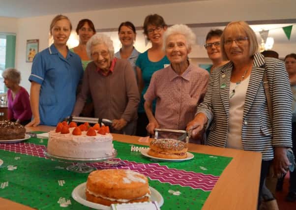 Staff and residents with the Bake off entries EMN-160709-084610001