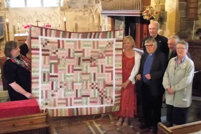 Judith Brodnicki, left, holding the quilt with clergy and members of the Thimbleby community. Photo by Bob Wayne EMN-160926-083528001