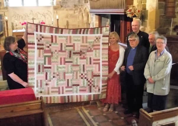 Judith Brodnicki, left, holding the quilt with clergy and members of the Thimbleby community. Photo by Bob Wayne EMN-160926-083528001