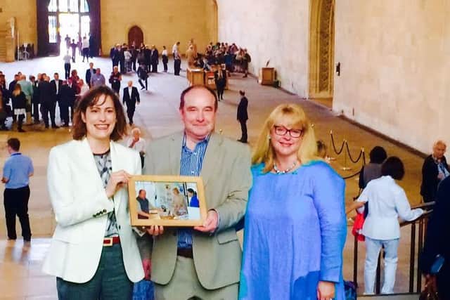 MP Victoria Atkins (left) with Russ and Sadie and the framed photo EMN-160809-162906001